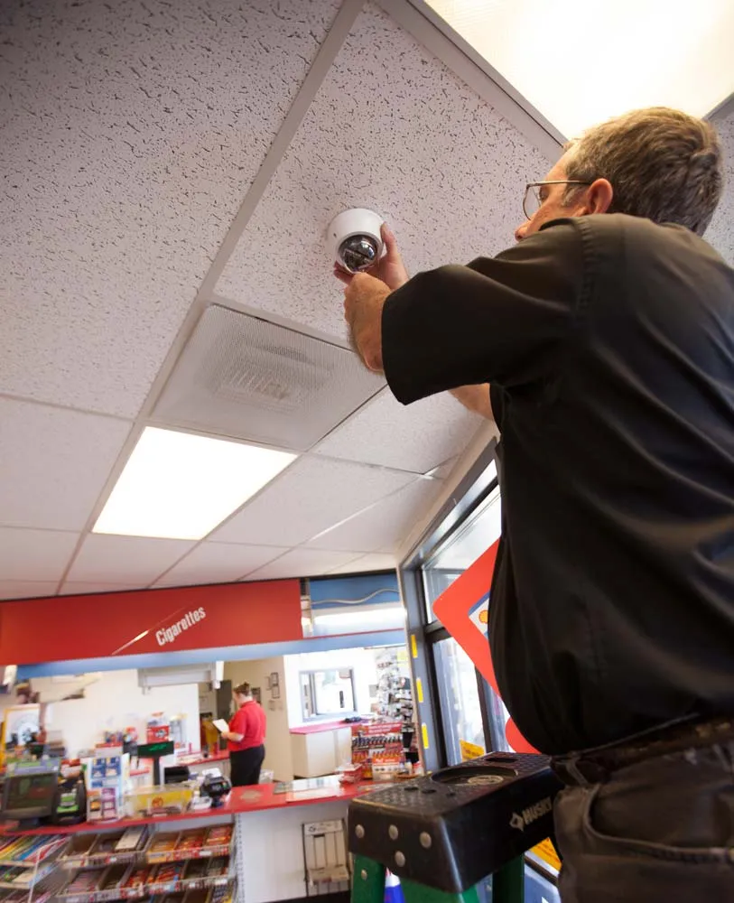 A technician installing a camera in a store