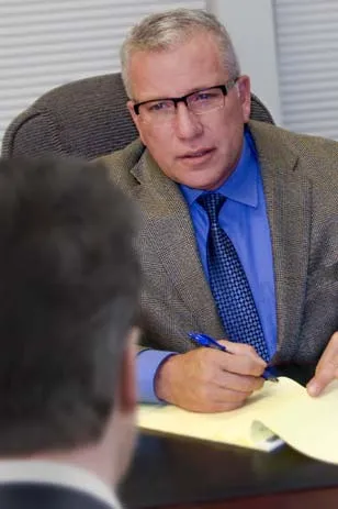 Sam Nigro at his desk taking a written statement
